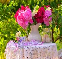 Яркие пионы в кувшине на столике